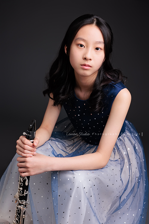 為了即將登場的音樂會，瑄帶著她的豎笛來拍攝音樂會寫真，穿上優雅的藍色系禮服，舉手投足間流露出屬於她的從容與氣質，這張是瑄坐著雙手扶拿著豎笛看著鏡頭的美麗模樣！