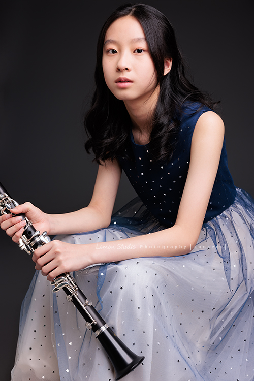 為了即將登場的音樂會，瑄帶著她的豎笛來拍攝音樂會寫真，穿上優雅的藍色系禮服，舉手投足間流露出屬於她的從容與氣質，這張是瑄坐著雙手扶拿著豎笛，帶著空靈的氣質專注地看著鏡頭的美麗模樣！