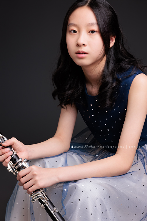 為了即將登場的音樂會，瑄帶著她的豎笛來拍攝音樂會寫真，穿上優雅的藍色系禮服，舉手投足間流露出屬於她的從容與氣質，這張是瑄坐著雙手扶拿著豎笛，帶著空靈的氣質沈穩地專注看著鏡頭的美麗模樣！