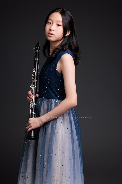 為了即將登場的音樂會，瑄帶著她的豎笛來拍攝音樂會寫真，穿上優雅的藍色系禮服，舉手投足間流露出屬於她的從容與氣質，這張是瑄手拿著豎笛身體有點側向地對著鏡頭，很沈穩寧靜地看著鏡頭的美麗模樣！