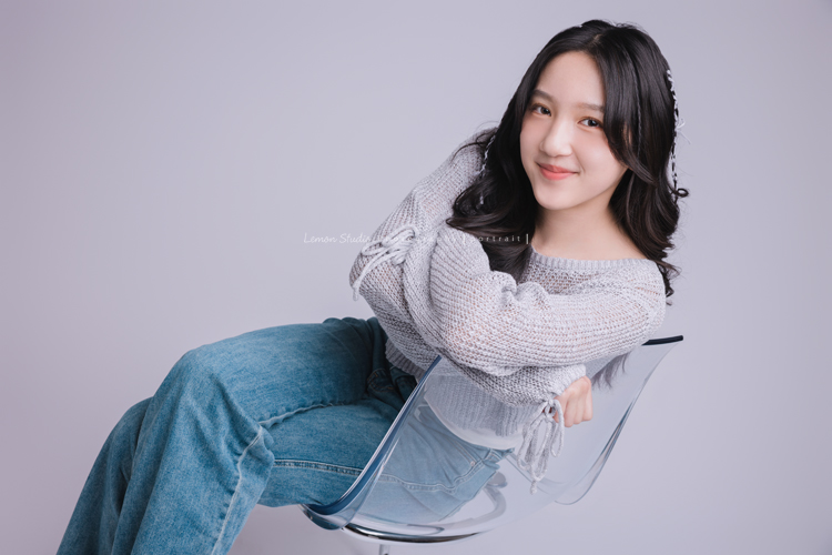 姊姊和妹妹分別來拍個人寫真，笑起來很甜美的姊姊很自在地做自己，在鏡頭前留下屬於這一刻的青春，這張是姊姊側坐在椅子上、看著鏡頭微笑的一張的個人寫真！