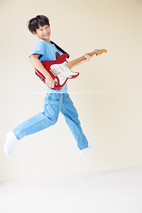 小妃媽麻一家帶著外婆來拍家庭攝影，外婆本來在鏡頭前有點靦腆，後來開始唱起歌來欲罷不能，一家人和外婆感情超好，在鏡頭前活潑且自然，這張是孩子抱著吉他跳起來看著鏡頭笑得很開心的一張很棒的個人寫真紀錄！