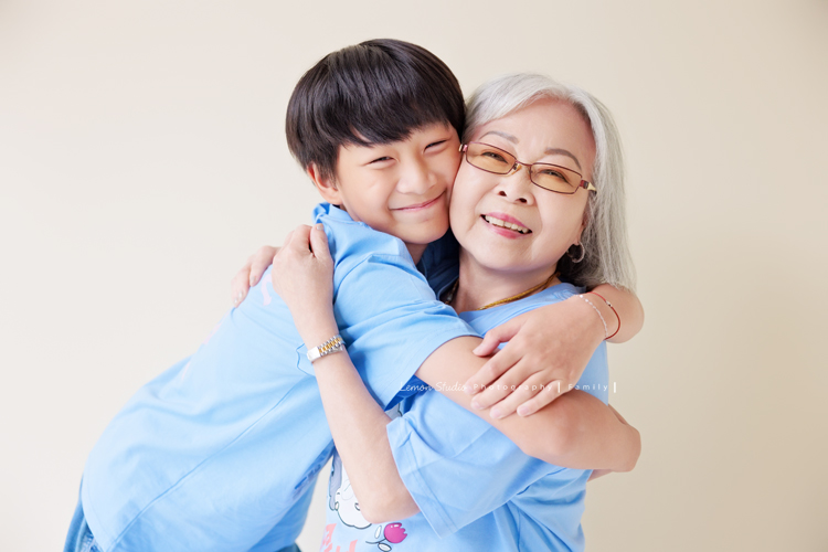 小妃媽麻一家帶著外婆來拍家庭攝影，外婆本來在鏡頭前有點靦腆，後來開始唱起歌來欲罷不能，一家人和外婆感情超好，在鏡頭前活潑且自然，這張是祖孫兩人抱在一起超有愛的祖孫互動寫真！