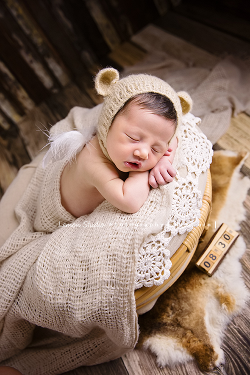 Diana媽麻和先生帶著剛出生的寶寶來拍新生兒攝影，外國人的爸拔和媽麻一起抱著寶寶，三人之間的互動自然又真摯，這是他們第一次的全家福，也是送給寶寶最有溫度美好的出生禮物，這張是寶寶穿著道具服、趴在可愛的小床上，睡著的可愛模樣，旁邊還有個小道具上面寫著寶寶的出生日期！