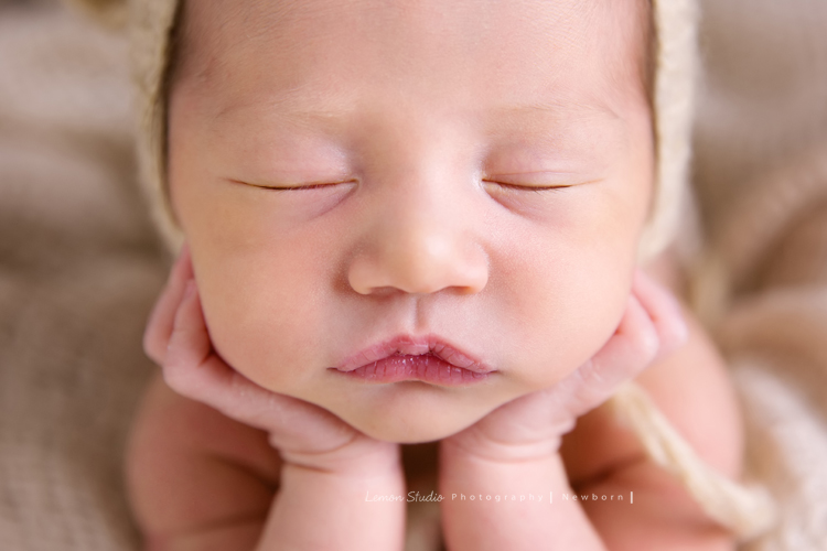 Diana媽麻和先生帶著剛出生的寶寶來拍新生兒攝影，外國人的爸拔和媽麻一起抱著寶寶，三人之間的互動自然又真摯，這是他們第一次的全家福，也是送給寶寶最有溫度美好的出生禮物，這張是寶寶穿著道具服雙手托著頭睡著的可愛模樣，這張是整張臉的特寫，超可愛的！