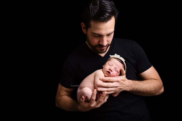 Diana媽麻和先生帶著剛出生的寶寶來拍新生兒攝影，外國人的爸拔和媽麻一起抱著寶寶，三人之間的互動自然又真摯，這是他們第一次的全家福，也是送給寶寶最有溫度美好的出生禮物，這張是爸拔將寶寶抱在胸前的幸福模樣！