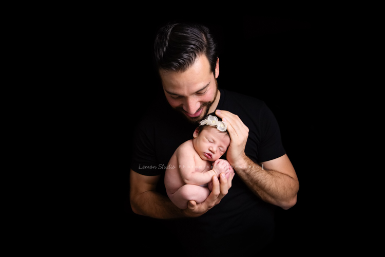 Diana媽麻和先生帶著剛出生的寶寶來拍新生兒攝影，外國人的爸拔和媽麻一起抱著寶寶，三人之間的互動自然又真摯，這是他們第一次的全家福，也是送給寶寶最有溫度美好的出生禮物，這張是爸拔用雙手將寶寶抱在胸前、看著寶寶微笑的幸福模樣！寶寶捲曲在爸拔的雙手中好美！