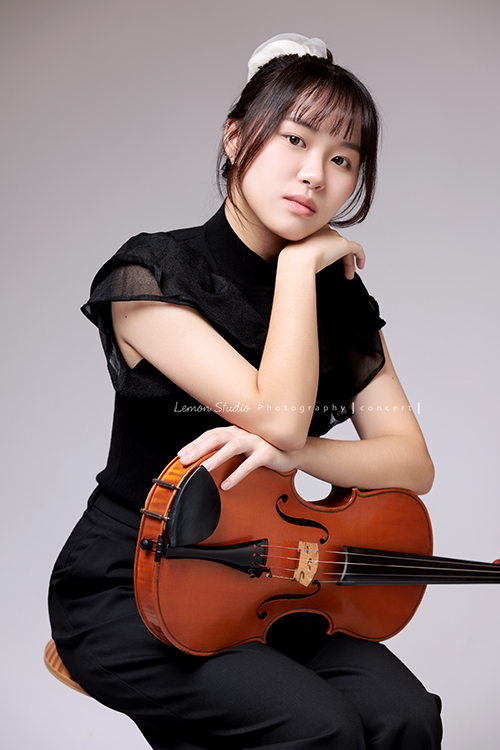 就讀高中音樂班的樂&妤，為了要辦的提琴音樂會，特地來拍攝音樂會寫真，兩人不僅默契十足，更散發著溫柔而有氣質的光彩，這張是妤一手扶著中提琴、一手放在胸前，酷酷地看著鏡頭，很美的一張音樂會寫真！
