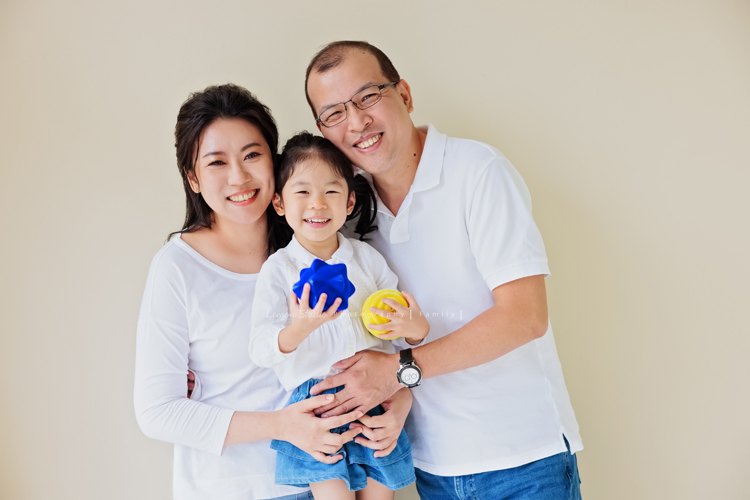 Jess媽一家第三次來拍照，這次是為了紀念雅滿四歲的時光，一家人總是自然又自在，照片裡流露出的，是日常中最真實舒服的模樣，這張是一家人穿白色上衣、藍色褲子或裙子的全家福，爸拔媽麻抱著雅，雅笑得好開心啊！