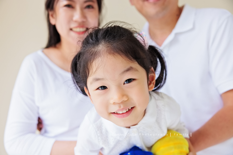 Jess媽一家第三次來拍照，這次是為了紀念雅滿四歲的時光，一家人總是自然又自在，照片裡流露出的，是日常中最真實舒服的模樣，這張是爸拔媽麻抱著雅，雅探頭看著鏡頭的俏皮模樣特寫！