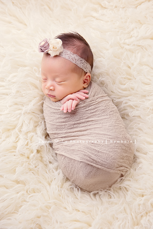 琄媽麻第二個寶貝的新生兒寫真，兩歲的小姊姊展現出滿滿的愛與呵護，小小的手輕輕撫摸著妹妹好有愛，而寶寶那努力撐著小頭的模樣，真是讓人一看就融化，怎麼看都看不膩，這張是寶寶被包在米咖啡色的包布裡，躺在白色毛茸茸的布上，兩隻手交疊著露出在布外，頭上戴著可愛的髮圈的睡著的模樣！