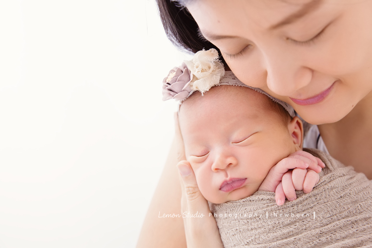 琄媽麻第二個寶貝的新生兒寫真，兩歲的小姊姊展現出滿滿的愛與呵護，小小的手輕輕撫摸著妹妹好有愛，而寶寶那努力撐著小頭的模樣，真是讓人一看就融化，怎麼看都看不膩，這張是寶寶包在米咖啡色的布裡、頭上戴著有花的髮帶，媽麻閉著眼睛低著頭溫柔地抱著寶寶的兩人合照！