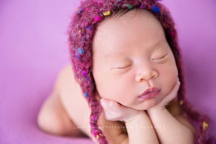 琄媽麻第二個寶貝的新生兒寫真，兩歲的小姊姊展現出滿滿的愛與呵護，小小的手輕輕撫摸著妹妹好有愛，而寶寶那努力撐著小頭的模樣，真是讓人一看就融化，怎麼看都看不膩，這張是寶寶趴在紫桃紅色的布上、頭上戴著紫色的帽子，兩手托著頭，睡著的臉部特寫的可愛模樣，超級可愛的！