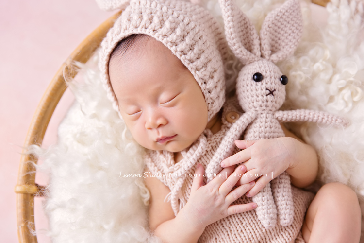 琄媽麻第二個寶貝的新生兒寫真，兩歲的小姊姊展現出滿滿的愛與呵護，小小的手輕輕撫摸著妹妹好有愛，而寶寶那努力撐著小頭的模樣，真是讓人一看就融化，怎麼看都看不膩，這張是寶寶躺在一個圓形的籐籃裡，穿著粉紅色的兔子裝、兩手抱著一隻粉紅色的兔子，睡著的可愛模樣，超級可愛的！