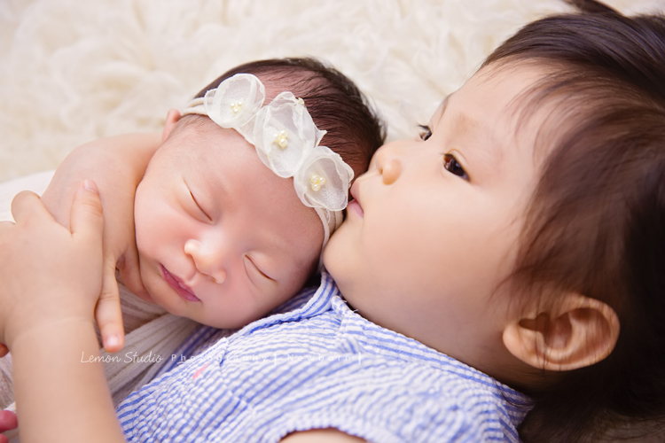 琄媽麻第二個寶貝的新生兒寫真，兩歲的小姊姊展現出滿滿的愛與呵護，小小的手輕輕撫摸著妹妹好有愛，而寶寶那努力撐著小頭的模樣，真是讓人一看就融化，怎麼看都看不膩，這張是寶寶包在白色的布裡、頭上戴著有白色的花的髮帶，小姊姊躺在寶寶旁邊溫柔地摟抱著寶寶的兩人合照！