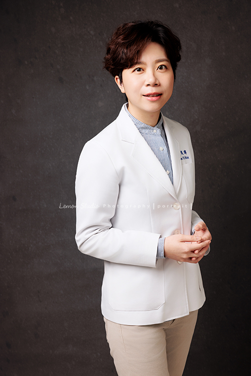 醫師Wei來拍照，鏡頭下展現出專屬於她的氣質，沉穩中帶著專業，自然流露智慧與自信，這張是醫師Wei雙手在前，沈穩自信地看著鏡頭微笑的醫師形象照！