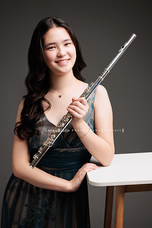 庭＆杉從歐洲返台時來拍音樂寫真照，兩姊妹都學習長笛，最後還留下了珍貴的姊妹合照，姊姊的美麗氣質在鏡頭下典雅動人，這張是姊姊庭一手拿長笛在身體前方、身體輕靠在桌旁、看著鏡頭笑得很甜美的一張音樂寫真照！