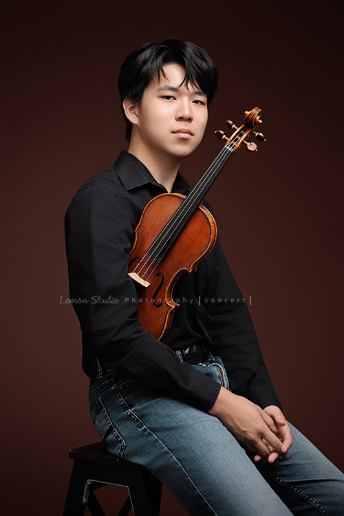 An 即將舉辦小提琴音樂會，也將申請國外大學音樂系，還記得小時候也曾來拍過照的他，如今已成長為帥氣又充滿才華的大哥哥，這張是An換上黑色的襯衫及牛仔褲，坐在椅子上，一手夾抱著小提琴，酷酷帥帥地看著鏡頭的一張很有味道、很帥氣的音樂會寫真照！