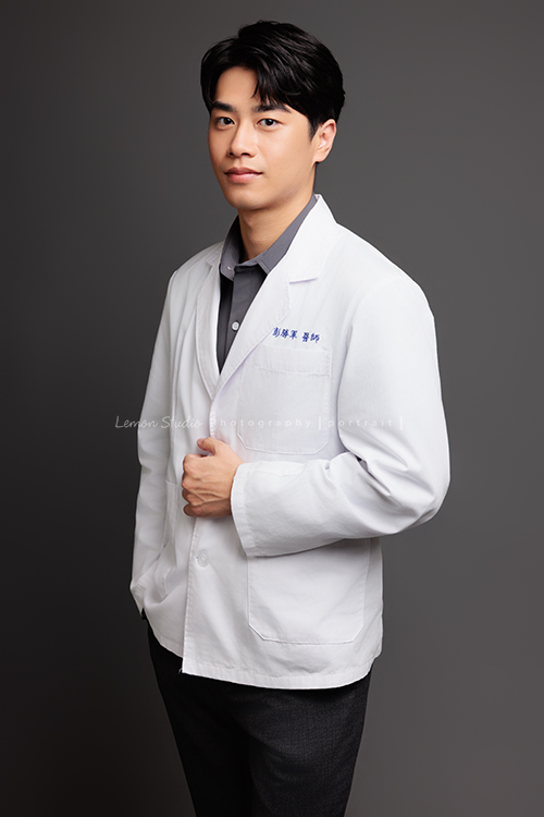 帥氣的彭醫師來拍照，黎爸替他記錄下許多不同的神情，有的溫和親切，有的專注沉穩，有的帶著鼓勵與信任，這張是彭醫師一手放口袋、一手抓著醫師袍、稍微側著身、很沈穩帶點微笑很帥氣的一張醫師形象照！