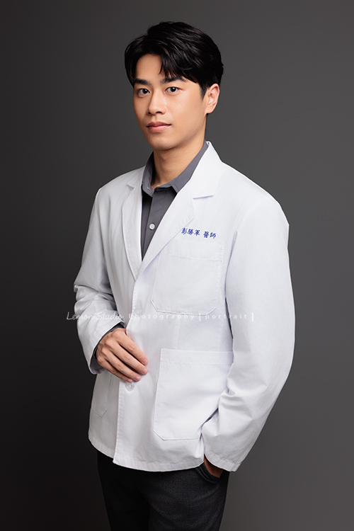 帥氣的彭醫師來拍照，黎爸替他記錄下許多不同的神情，有的溫和親切，有的專注沉穩，有的帶著鼓勵與信任，這張是彭醫師一手放口袋、一手抓著醫師袍、稍微側著身、很沈穩很帥氣的一張醫師形象照！