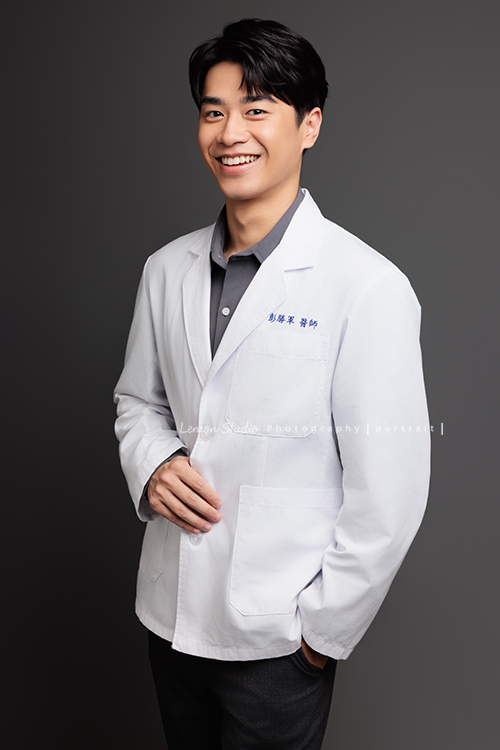 帥氣的彭醫師來拍照，黎爸替他記錄下許多不同的神情，有的溫和親切，有的專注沉穩，有的帶著鼓勵與信任，這張是彭醫師一手放口袋、一手抓著醫師袍、稍微側著身、笑容很燦爛的一張醫師形象照！