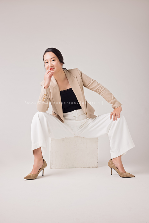 羌虎跨域生活創辦人南雁來拍照，這張是南雁坐在箱子上，穿高跟鞋、兩腳跨開、很豪邁地看著鏡頭的形象照！