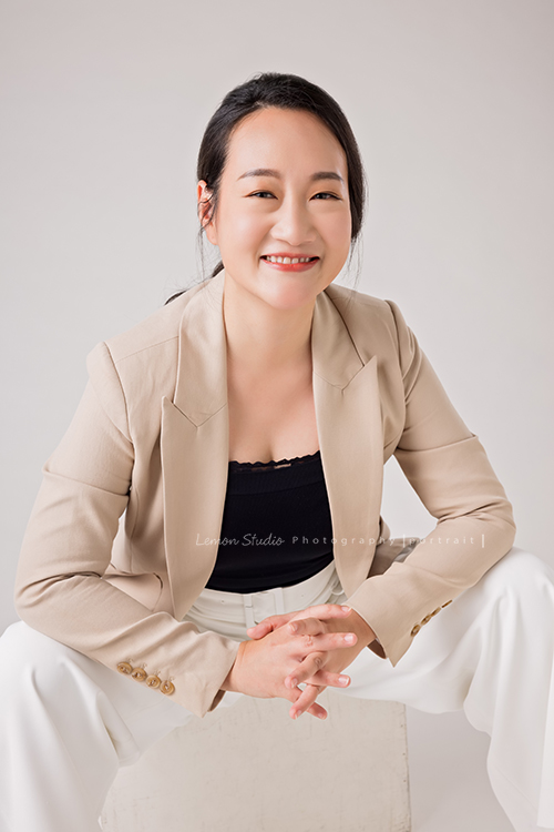 羌虎跨域生活創辦人南雁來拍照，這張是南雁坐在箱子上，穿高跟鞋、兩腳跨開、很陽光地看著鏡頭微笑的形象照！