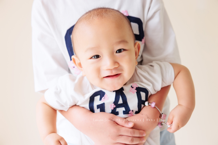 珈平媽麻一家第六次來拍照，這回多了一位新成員，櫟櫟當姊姊了，剛滿一歲的弟弟一舉一動都可愛得讓人融化，這張是櫟櫟抱著弟弟，弟弟很可愛地笑著看鏡頭！