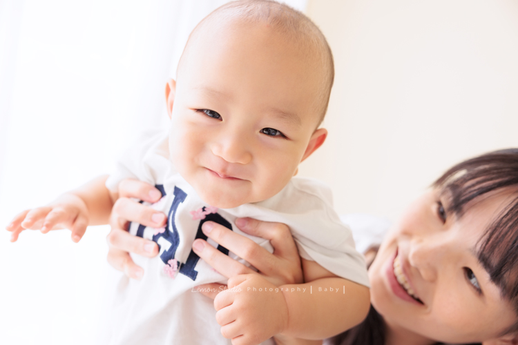 珈平媽麻一家第六次來拍照，這回多了一位新成員，櫟櫟當姊姊了，剛滿一歲的弟弟一舉一動都可愛得讓人融化，這張是媽麻抱著弟弟，弟弟俏皮地開心地笑著看鏡頭！