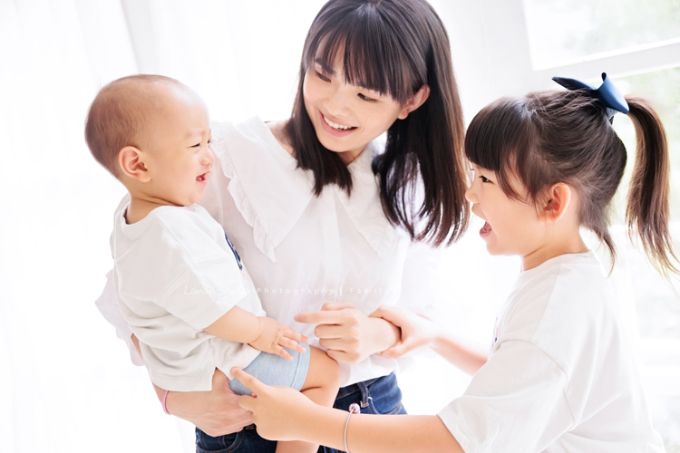 珈平媽麻一家第六次來拍照，這回多了一位新成員，櫟櫟當姊姊了，剛滿一歲的弟弟一舉一動都可愛得讓人融化，這張是媽麻抱著弟弟，並看著弟弟開心地笑著，姊姊和弟弟兩人可愛的互動的一瞬間的相片！