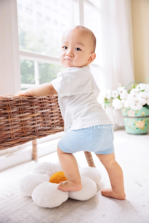 珈平媽麻一家第六次來拍照，這回多了一位新成員，櫟櫟當姊姊了，剛滿一歲的弟弟一舉一動都可愛得讓人融化，這張是弟弟扶著椅子站著、轉頭看鏡頭的一張可愛弟弟的相片！