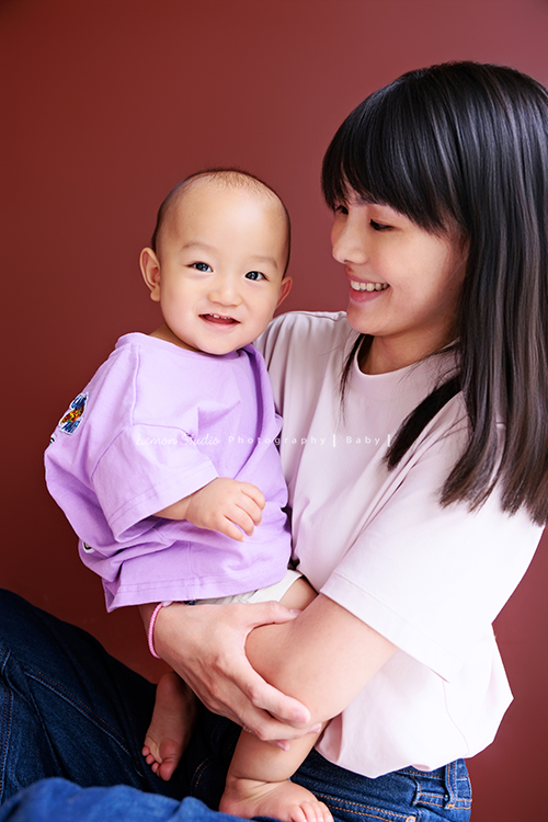 珈平媽麻一家第六次來拍照，這回多了一位新成員，櫟櫟當姊姊了，剛滿一歲的弟弟一舉一動都可愛得讓人融化，這張是媽麻抱著弟弟笑得很開心，弟弟看著鏡頭微笑的相片！