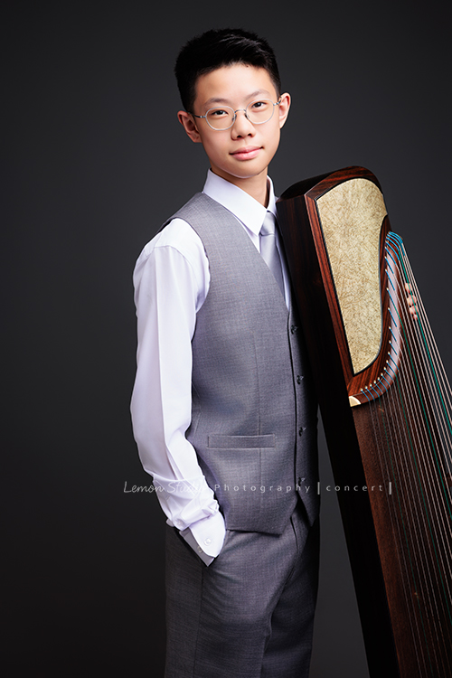 Benson帶著古箏走進鏡頭，穿上馬面裙的那一刻，彷彿穿越時空回到古代，同時又有如舞台上的模特兒般自信，一次拍下古韻與現代交織的獨特風格，這張是Benson穿上西裝背心、一手放口袋，一手扶著古箏、看著鏡頭微笑的一張音樂會寫真！