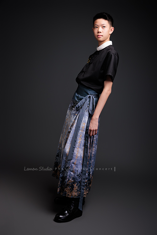 Benson帶著古箏走進鏡頭，穿上馬面裙的那一刻，彷彿穿越時空回到古代，同時又有如舞台上的模特兒般自信，一次拍下古韻與現代交織的獨特風格，這張是Benson穿著馬面裙、側身兩手輕鬆地擺在身旁、沒有看鏡頭、一張很有意境的全身的音樂會寫真！