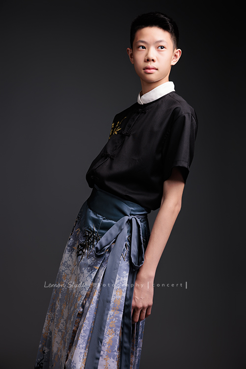 Benson帶著古箏走進鏡頭，穿上馬面裙的那一刻，彷彿穿越時空回到古代，同時又有如舞台上的模特兒般自信，一次拍下古韻與現代交織的獨特風格，這張是Benson穿著馬面裙、側身兩手輕鬆地擺在身旁、看向遠方、一張很有意境的音樂會寫真！