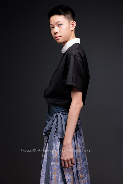 Benson帶著古箏走進鏡頭，穿上馬面裙的那一刻，彷彿穿越時空回到古代，同時又有如舞台上的模特兒般自信，一次拍下古韻與現代交織的獨特風格，這張是Benson穿著馬面裙、側身兩手輕鬆地擺在身旁、很有自信的眼神轉過來看著鏡頭、一張很有意境的音樂會寫真！