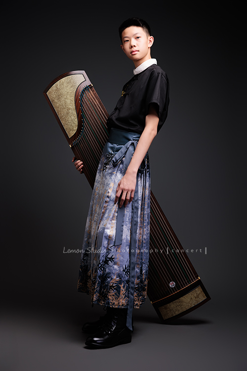 Benson帶著古箏走進鏡頭，穿上馬面裙的那一刻，彷彿穿越時空回到古代，同時又有如舞台上的模特兒般自信，一次拍下古韻與現代交織的獨特風格，這張是Benson穿著馬面裙、一手抱著古箏有自信地看著鏡頭的全身音樂會寫真！