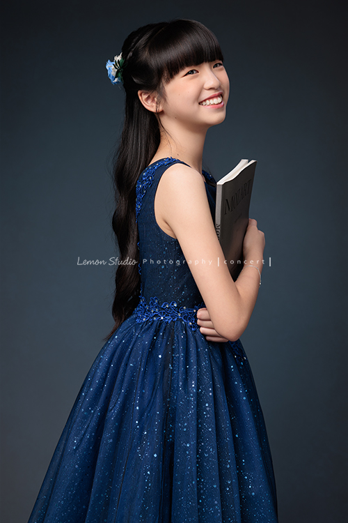 畇為了鋼琴獨奏會，特地前來拍攝音樂寫真，參加過無數比賽並屢獲佳績的畇，鏡頭下的她自信、沉著又專注，很開心能為如此優秀的畇留下美好的紀錄，這張是畇身穿深藍色的削肩禮服，手拿著樂譜側身回頭看向遠方，畇笑得很美的一張音樂寫真照！