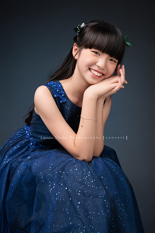 畇為了鋼琴獨奏會，特地前來拍攝音樂寫真，參加過無數比賽並屢獲佳績的畇，鏡頭下的她自信、沉著又專注，很開心能為如此優秀的畇留下美好的紀錄，這張是畇身穿深藍色的削肩禮服，坐著雙手在臉龐，畇看著鏡頭笑得很甜美的一張音樂寫真照！