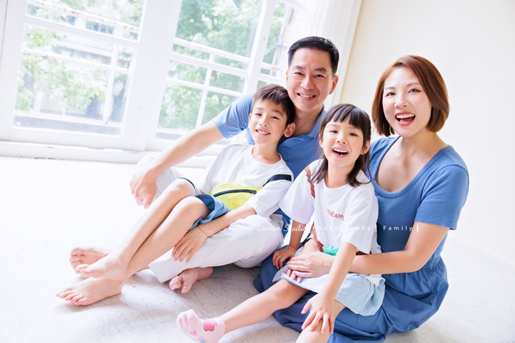 Cheryl媽麻一家第二次來拍照，兄妹倆的成長清晰可見，爸媽的用心陪伴，化作最溫暖的背景，這張是一家四口身穿藍色系衣服爸拔媽麻坐在地上抱著哥哥姊姊的全家福寫真！