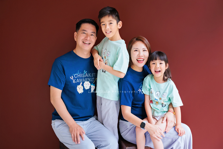 Cheryl媽麻一家第二次來拍照，兄妹倆的成長清晰可見，爸媽的用心陪伴，化作最溫暖的背景，這張是一家四口在咖啡紅的背景前拍攝的全家福寫真！