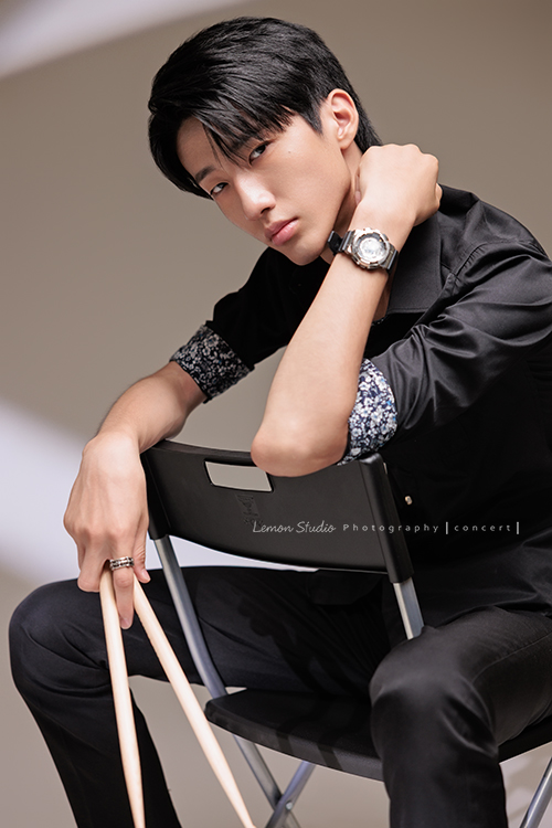 又高又有型的 Xavier前來拍攝音樂會寫真，他的專長是馬林巴木琴，手握鼓棒入鏡時，每一張都散發著時尚與帥氣的氣息，這張是Xavier坐在椅子上一手拿著鼓棒、一手在身旁酷酷地看著鏡頭的音樂會寫真照！