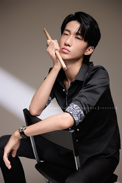 又高又有型的 Xavier前來拍攝音樂會寫真，他的專長是馬林巴木琴，手握鼓棒入鏡時，每一張都散發著時尚與帥氣的氣息，這張是Xavier坐在椅子上一手拿著鼓棒並拖著下巴酷酷地看著鏡頭的音樂會寫真照！