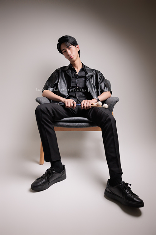 又高又有型的 Xavier前來拍攝音樂會寫真，他的專長是馬林巴木琴，手握鼓棒入鏡時，每一張都散發著時尚與帥氣的氣息，這張是Xavier坐著手拿著鼓棒酷酷地看著鏡頭的音樂會寫真照！