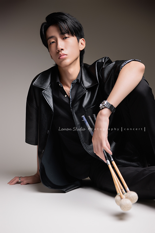 又高又有型的 Xavier前來拍攝音樂會寫真，他的專長是馬林巴木琴，手握鼓棒入鏡時，每一張都散發著時尚與帥氣的氣息，這張是Xavier坐在地上一手拿著鼓棒一手扶坐在地板上、酷且帥氣地看著鏡頭的音樂會寫真照！