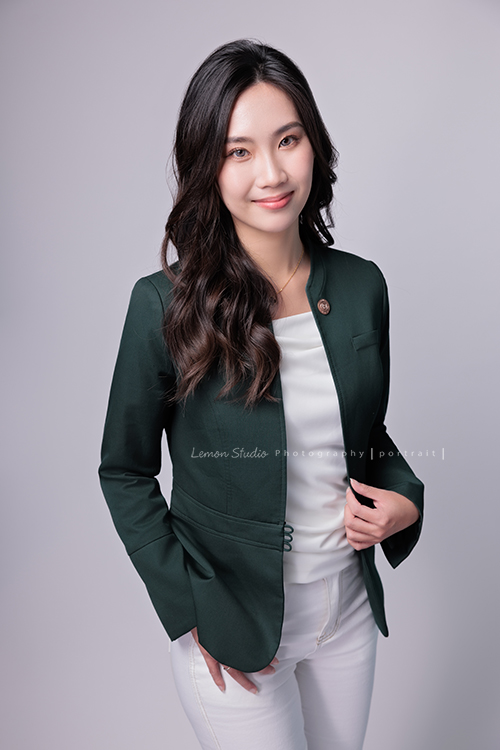 這次受邀到高雄住商不動產拍攝形象照，裕誠富民加盟店的店東們用心經營，店內裝潢充滿設計感，團隊之間彼此協作，展現出滿滿的凝聚力，今年也再次榮獲 2025 金仲獎楷模，這張是一位女同事的形象照，同事手拉著外套，另一手插口袋，看著鏡頭沈穩地微笑的一張很美的形象照！