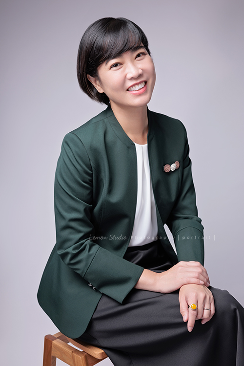 這次受邀到高雄住商不動產拍攝形象照，裕誠富民加盟店的店東們用心經營，店內裝潢充滿設計感，團隊之間彼此協作，展現出滿滿的凝聚力，今年也再次榮獲 2025 金仲獎楷模，這張是另一位女同事的形象照，同事坐在椅子上，側著頭看著鏡頭笑得很開心的一張很美的形象照！