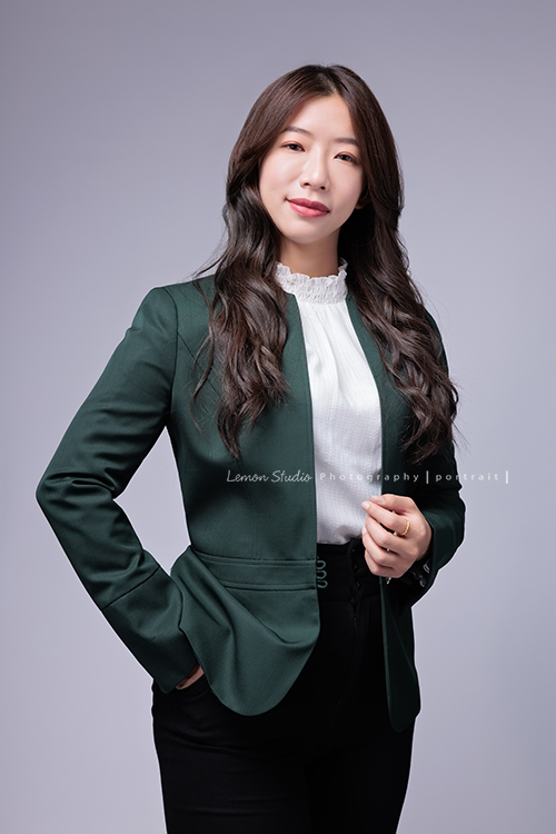 這次受邀到高雄住商不動產拍攝形象照，裕誠富民加盟店的店東們用心經營，店內裝潢充滿設計感，團隊之間彼此協作，展現出滿滿的凝聚力，今年也再次榮獲 2025 金仲獎楷模，這張另一位女同事的形象照，同事手拉著外套，另一手插口袋，看著鏡頭沈穩地微笑的一張很美的形象照！