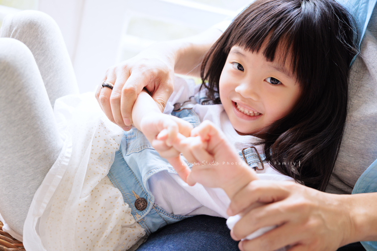 Ida媽麻一家第三次來拍照，四歲半和一歲半的姊弟倆，笑容與童趣洋溢，爸拔媽麻也陪著一起玩得很開心，這張是姊姊躺在爸拔身上正在玩耍、看著鏡頭微笑的一張姊姊的個人兒童寫真！