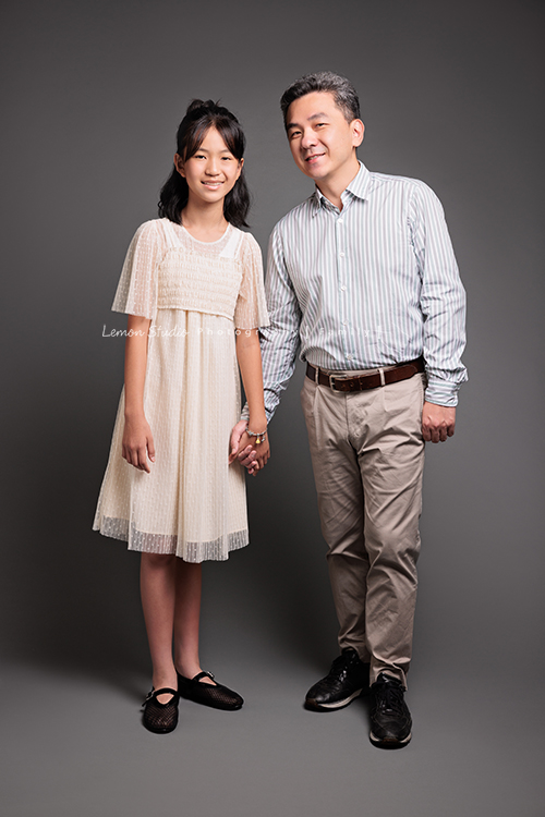 Coco媽麻一家第二次來拍照，依舊優雅美麗的Coco媽麻，女兒也悄悄長成漂亮的青少女，這張是爸拔和女兒的合照，兩人站著、爸拔牽著女兒的手，兩人看著鏡頭微笑，也是好幸福的一個畫面！
